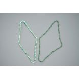 Two Chinese green jade beads necklaces, one with silver lock, 19/20th C.