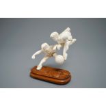 A rare Chinese carved ivory group of two boys playing football, 1st half 20th C.