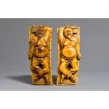 A pair of Chinese carved ivory figures of resting men on a bed, 19th C.