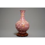A Chinese ruby-ground famille rose bottle vase with dancing boys, Qianlong mark, 19/20th C.