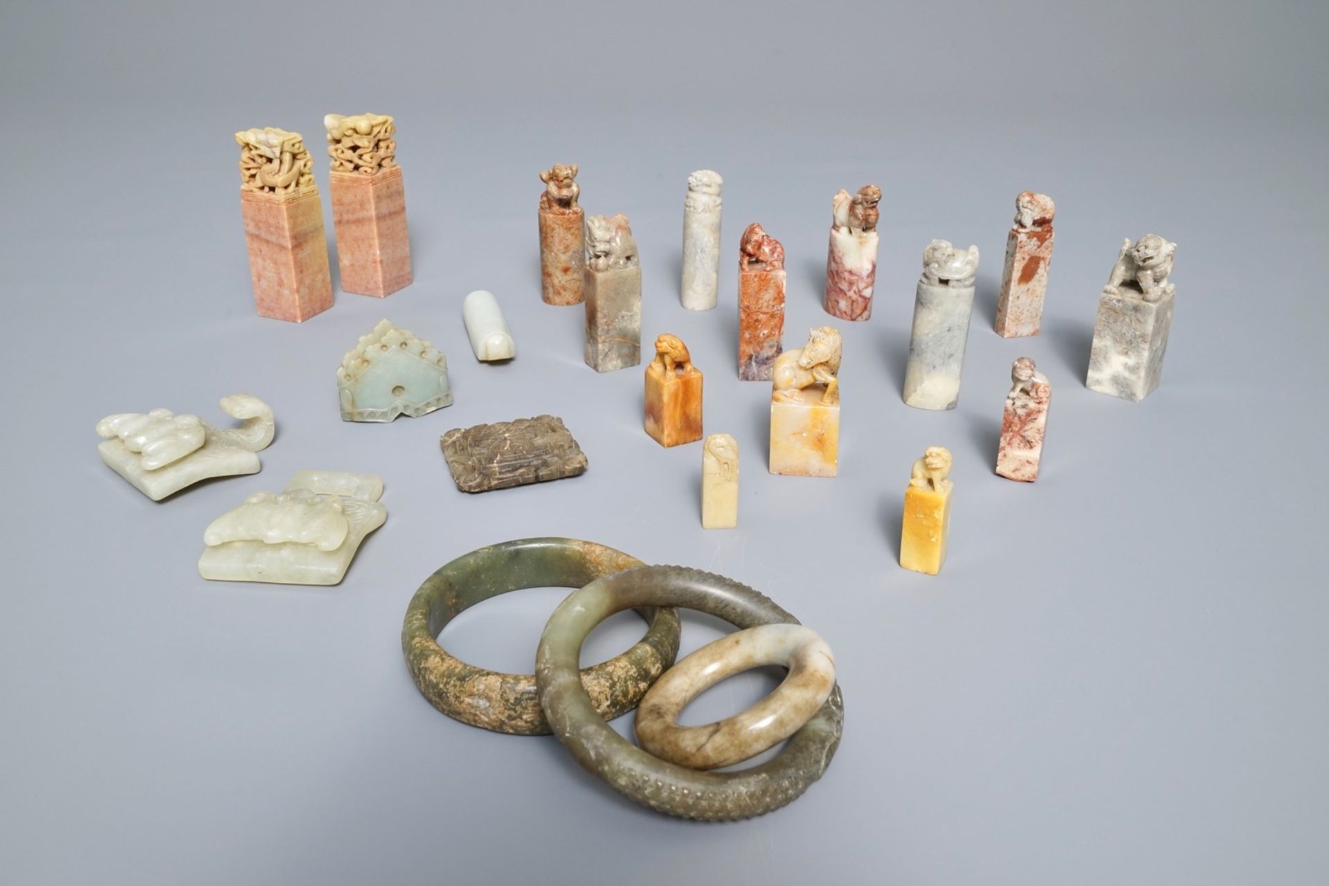 A collection of 23 Chinese jade, soapstone and hardstone seals, carvings, hooks and bangles, 19/