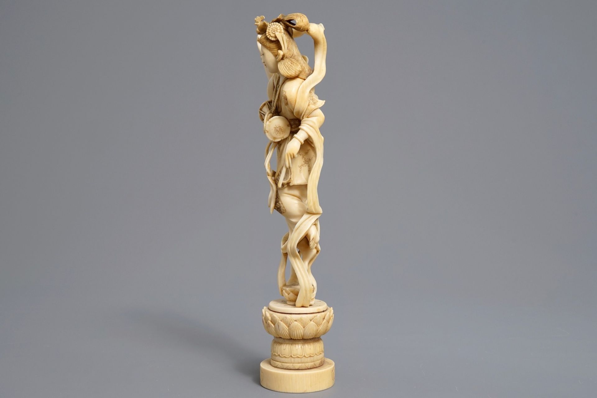 A Japanese carved ivory figure of a lady with a drum on a lotus throne, Meiji, 19th C. - Image 3 of 8
