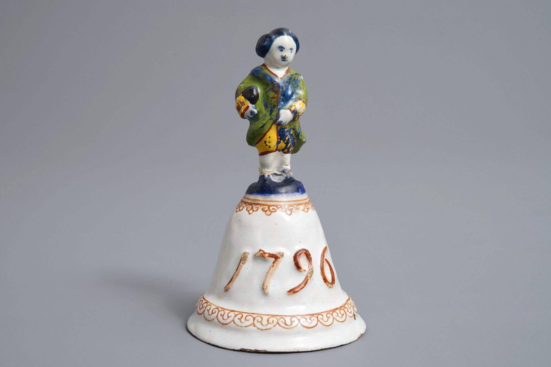 A polychrome Dutch Delft table bell with a noblemand, dated 1796