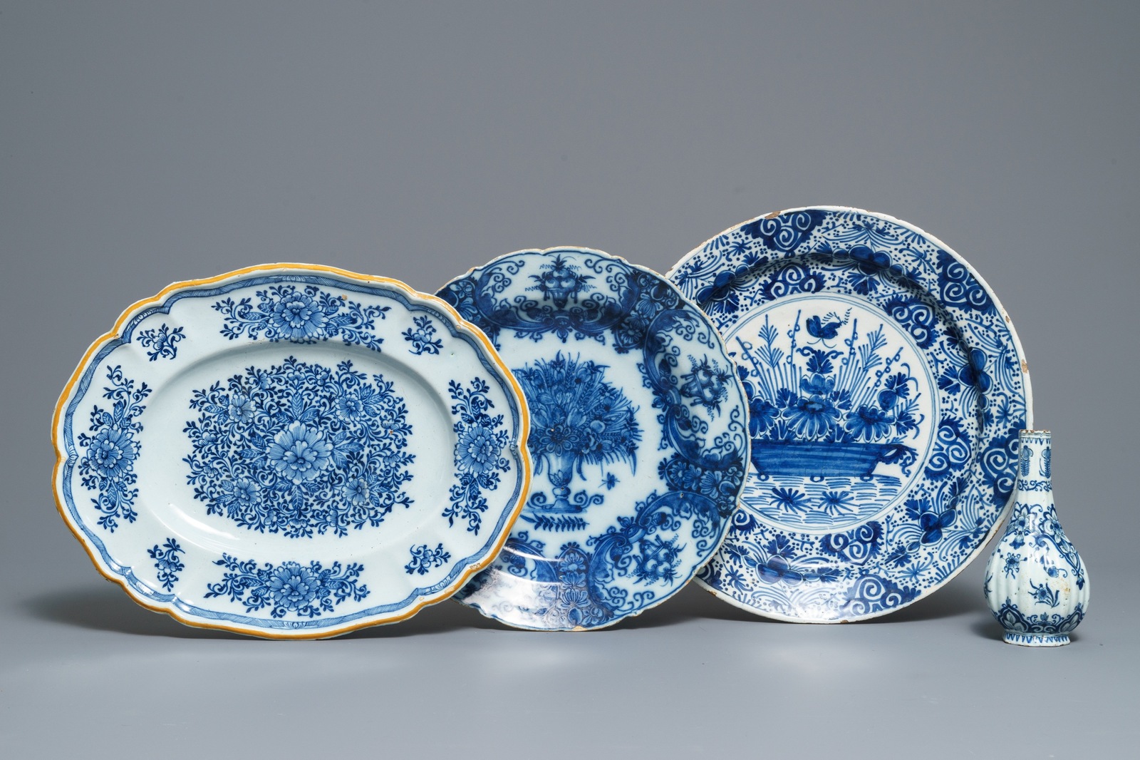 Two Dutch Delft blue and white chargers, an oval dish and a vase, 18th C.