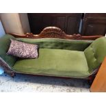 A vintage carved wood framed scroll-end sofa with upholstered carved back