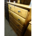 A honey pine chest of drawers with two short above four long with grey metal effect handles