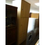 A tall narrow lightwood IKEA cupboard & drawer unit