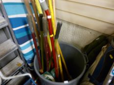 Quantity of long handled garden tools in a plastic bin, ironing board etc