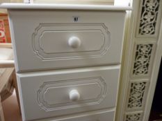White melamine three drawer bedside chest and a slim white painted storage cupboard