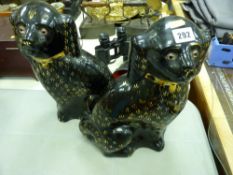 Pair of large seated black and gilt Staffs dogs