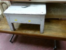 Vintage painted wooden stool and a slim teak coffee table on castor supports