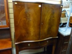 Serpentine front drinks cabinet with lower frieze drawers on tapering supports with spade feet