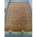 A PERSIAN WOOLLEN CARPET, multi-bordered on a rust ground with central repeating pattern and