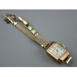 A NINE CARAT GOLD OBLONG DIAL LADY'S WRISTWATCH with tapered style yellow metal bracelet, 2.2 grms