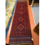 A HAND KNOTTED MESHWANI RUNNER CARPET, red and blue ground with repeating diamond central pattern