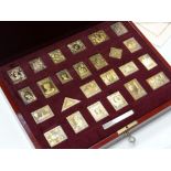 A cased set of twenty-five gold plated solid silver Empire Collection stamps