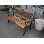 A black metal ended & slatted garden bench (outside)