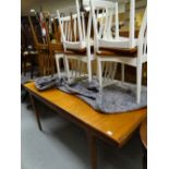 A 1960s G-plan style teak extending dining table with six similar matching spindle back chairs, five