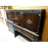 An antique reproduction dark oak raised sideboard with two cupboards above two drawers