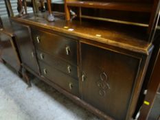 A vintage oak sideboard on raised feet with three cupboards flanked by two doors