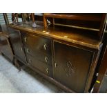 A vintage oak sideboard on raised feet with three cupboards flanked by two doors