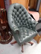 A green high button backed leather swivel desk chair