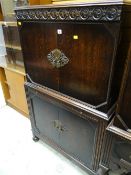 An antique reproduction dark oak cabinet with glass pull-out shelf (matching previous lot)