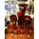 A tray of red glass items including vases, drinking glasses etc