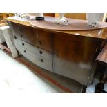 A reproduction mahogany bow fronted sideboard with four drawers flanked by two cupboards on raised