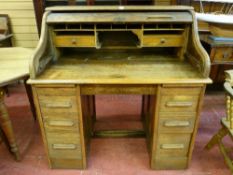 AN EARLY TO MID 20th CENTURY OAK ROLL TOP DESK, typical form with interior top arrangement of