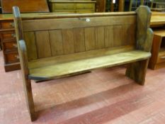 A VINTAGE PINE CHURCH PEW with shaped ends, 92 cms high, 137 cms wide, 42 cms deep overall
