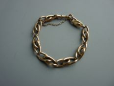 A HEAVY NINE CARAT GOLD LINK BRACELET with swivel clip and safety chain, 23 cms long