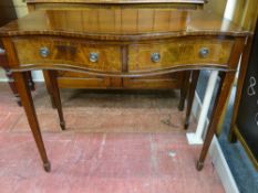 A REPRODUCTION MAHOGANY SERPENTINE FRONT SIDE TABLE having twin frieze drawers with ring pull