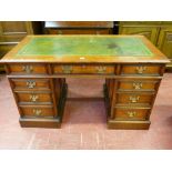 A GOOD OAK TWIN PEDESTAL DESK having a gilt tooled green leather insert over a three drawer frieze