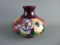 A MOORCROFT 'PANSY' 11 cms HIGH BULBOUS SQUAT VASE, designed by Rachel Bishop, decorated on a purple