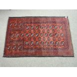 A VINTAGE BALUCHI RUG of pleasant proportions, red ground with octagonal medallions in block