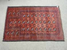 A VINTAGE BALUCHI RUG of pleasant proportions, red ground with octagonal medallions in block