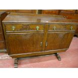 A VINTAGE OAK RAILBACK SIDEBOARD having two drawers and two cupboard doors with blind fret