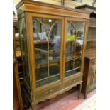 AN EDWARDIAN INLAID MAHOGANY TWO DOOR DISPLAY CABINET, the doors with shaped moulding and part cloth