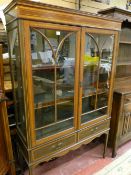 AN EDWARDIAN INLAID MAHOGANY TWO DOOR DISPLAY CABINET, the doors with shaped moulding and part cloth