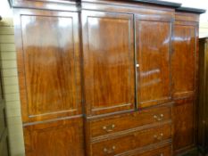 A REGENCY MAHOGANY BREAKFRONT WARDROBE having an inverted curve cornice with reeded moulding over