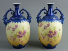 A PAIR OF AUSTRIAN TWIN HANDLED VASES having floral decorated blush ground bodies, acanthus leaf