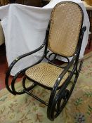 A 20th CENTURY THONET STYLE BENTWOOD ROCKING CHAIR, ebonized with cane work back and seat, 105 cms