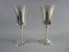 A PAIR OF SILVER CHAMPAGNE FLUTES of waisted form on circular footed stems, Birmingham 1970, 11.2