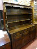 A REPRODUCTION OAK PRIORY STYLE DRESSER, the two shelf rack with decorative canopy and shaped