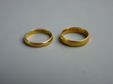 TWO SMALL TWENTY TWO CARAT GOLD WEDDING BANDS, one with worn exterior decoration, the other plain,