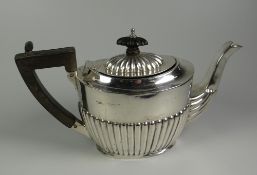 A BACHELOR SIZE SILVER TEAPOT having a composite handle and knop and having a fluted body, hallmarks