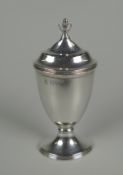 A SILVER PEPPERETTE of ovoid form raised over an oval base in the Georgian style, Chester 1920, 1.