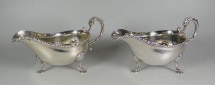 A PAIR OF SILVER SAUCE-BOATS, raised over pad feet with scallop terminals and with feathered rims