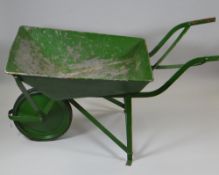 A GREEN PAINTED METAL VINTAGE WHEELBARROW with rubber tyre wheel